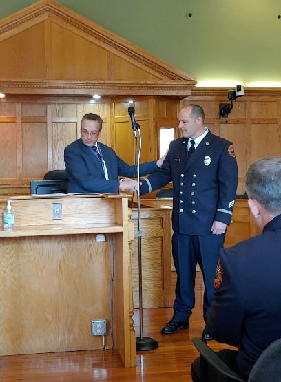Mayor Michael McCabe congratulating Fire Captain Chris Kane