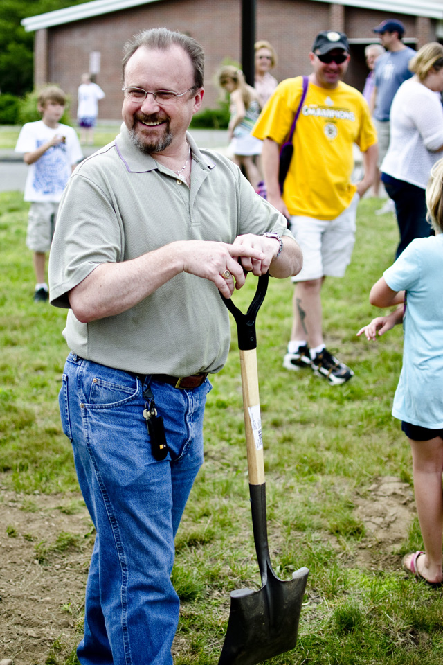 Councilor Rick Onofrey smiles holding shovel