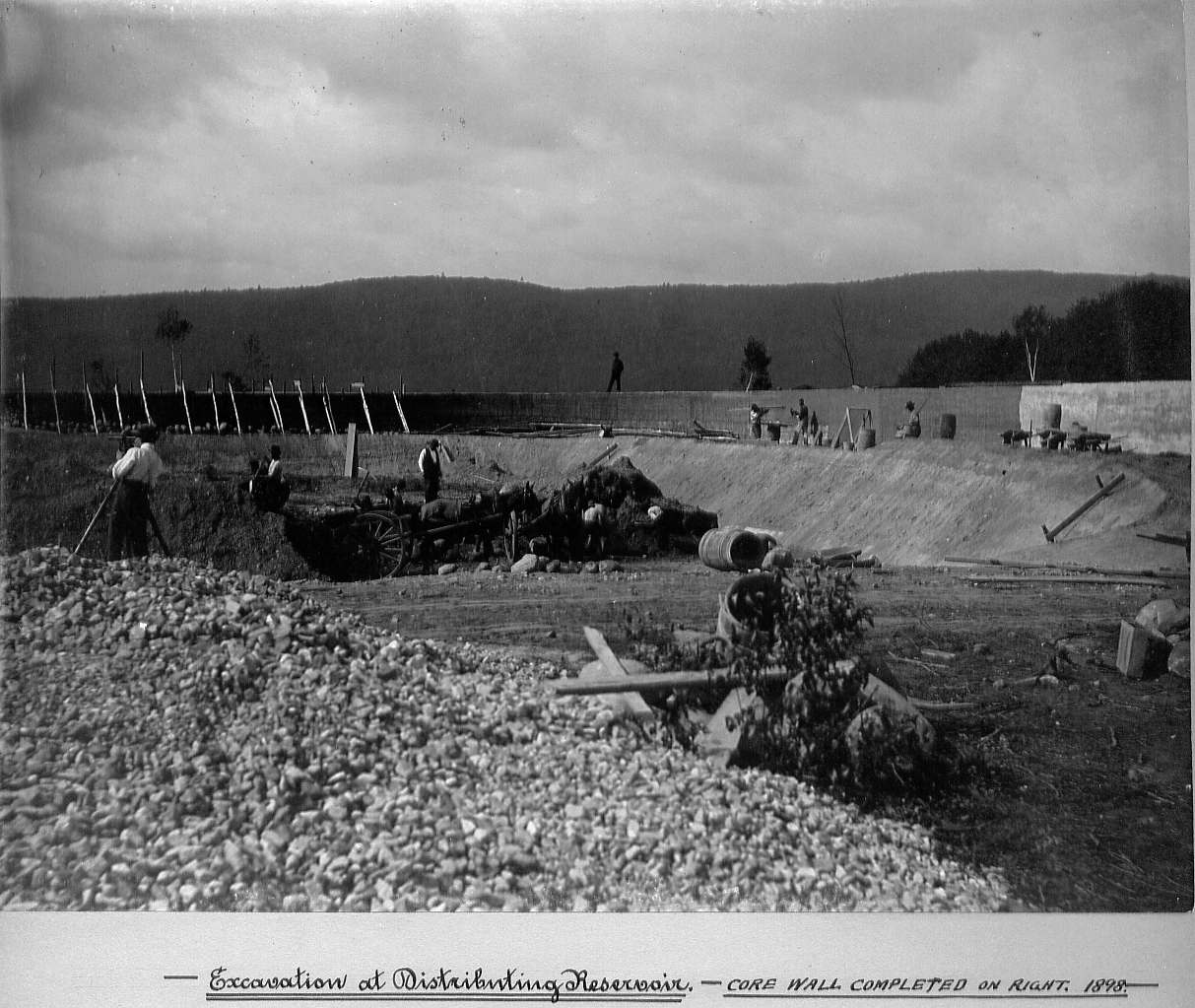 Men excavating and built wall on right